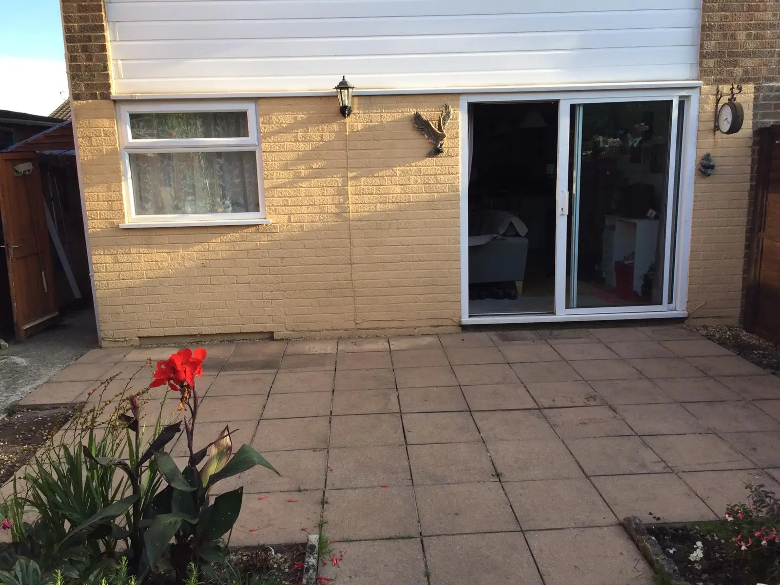 Concrete slab patio behind a house with sliding patio doors